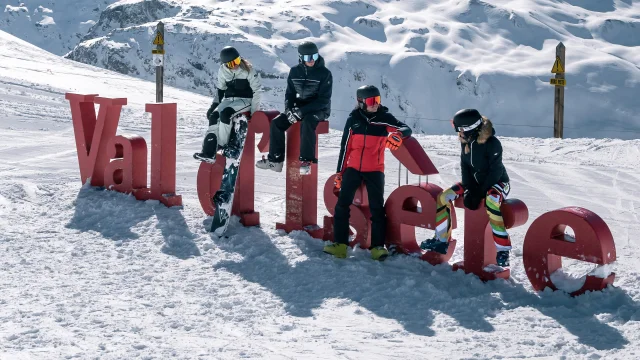 Sciatori e snowboarder davanti alle lettere della Val d'Isère