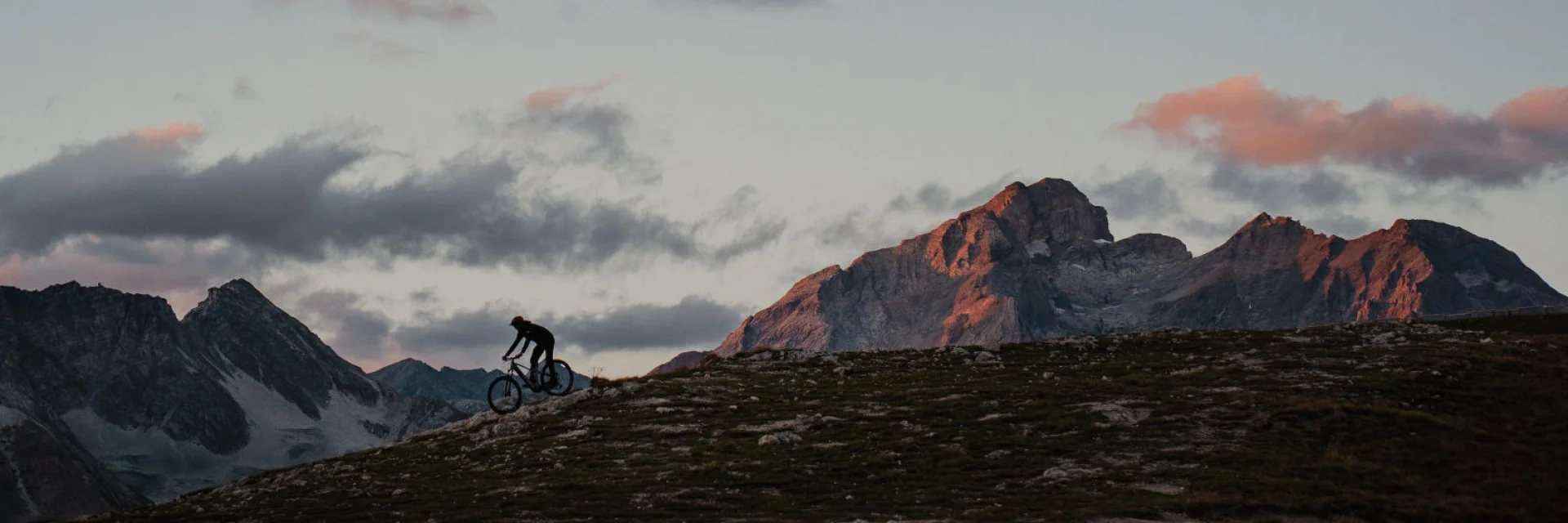 Uomo in E-Bike in cima alla Solaise in Val d'Isère con il tramonto