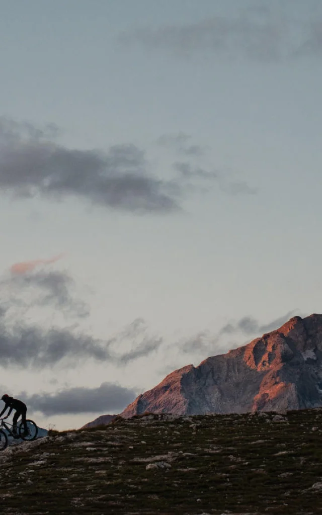 Uomo in E-Bike in cima alla Solaise in Val d'Isère con il tramonto