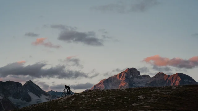 Uomo in E-Bike in cima alla Solaise in Val d'Isère con il tramonto