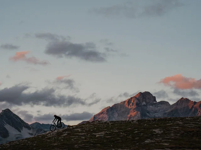 Uomo in E-Bike in cima alla Solaise in Val d'Isère con il tramonto