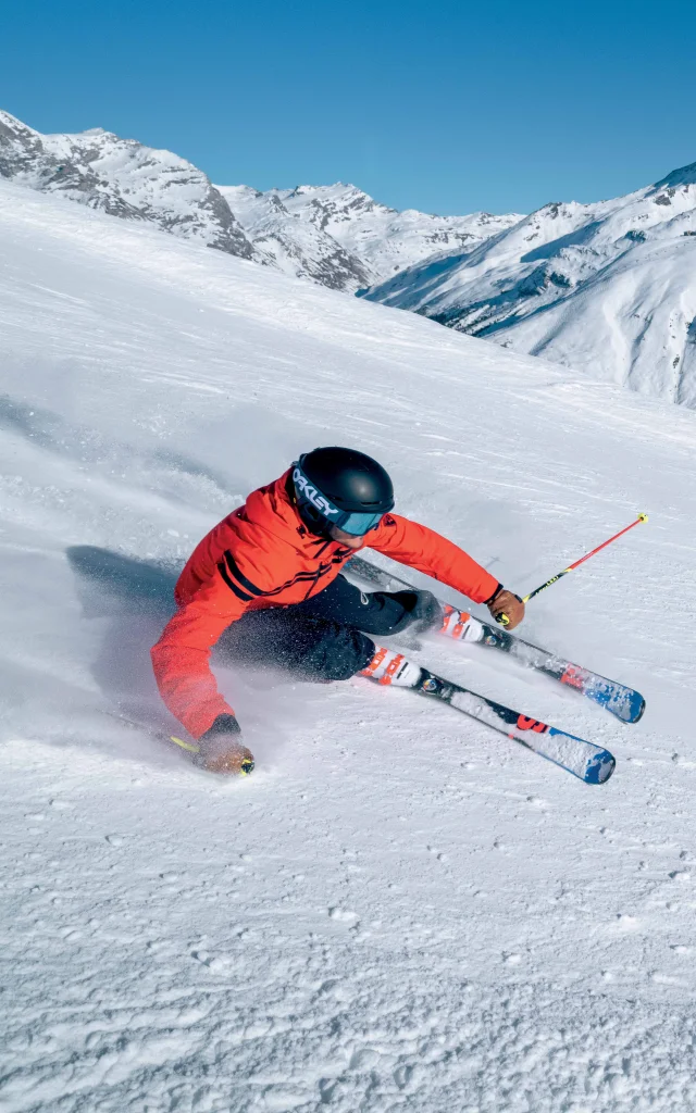 Sciatore in corsa lungo le piste della Val d'Isère