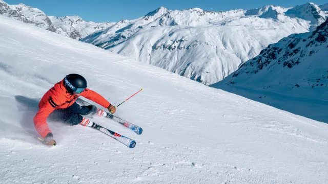 Sciatore in corsa lungo le piste della Val d'Isère