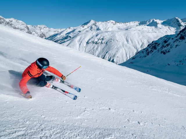 Sciatore in corsa lungo le piste della Val d'Isère